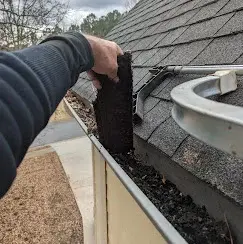 Gutter cleaning — clearing debris from a residential gutter in Cartersville GA